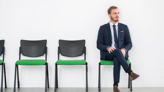 Un homme assis dans une salle d'attente.