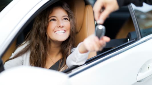 Une femme au volant d'une voiture.