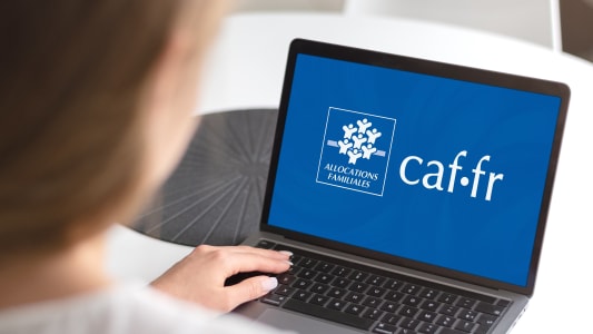 Une personne devant la page d'accueil de la CAF sur son ordinateur.