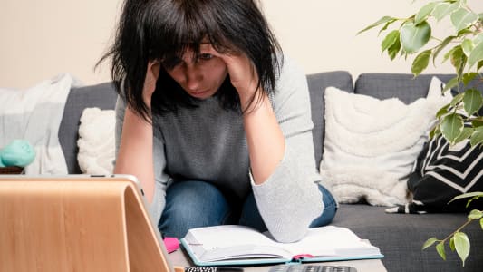 Une femme se prend la tête entre les mains.