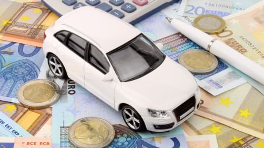 Une voiture miniature sur des billets.