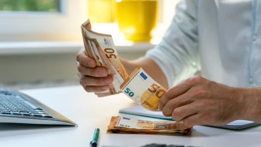 homme comptant des billets