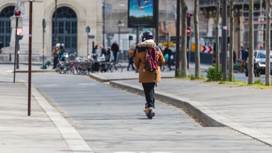 Une personne circulant en trottinette électrique.