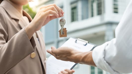 Bail, location et vente de maison. Agent immobilier tenant la clé d'une nouvelle maison ou d'un bien immobilier. Louer une maison, ventes, crédit immobilier, assurance, vendeur, concessionnaire, achat, vente, emménagement.