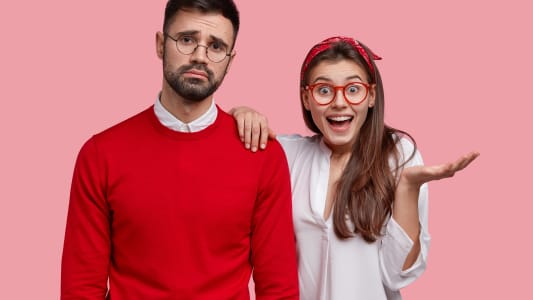 Une femme lve la paume, la main sur l'paule d'un homme qui a une expression triste.