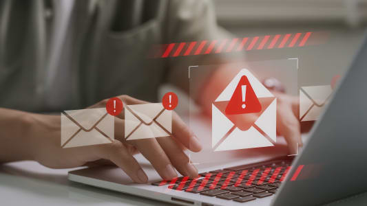 Personne utilisant un ordinateur portable avec des alertes de scurit email.