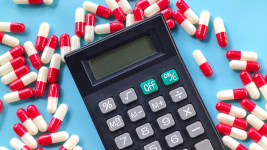 Une calculatrice et des capsules rouges et blanches sur fond bleu