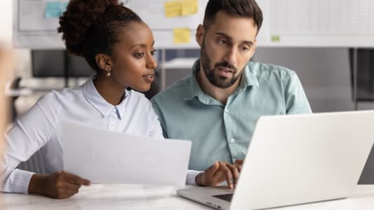 Deux collgues travaillant ensemble sur un document, vrifiant les dtails de l'accord.