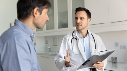 Mdecin discutant avec un patient dans un cabinet mdical.