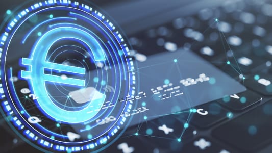 Gros plan sur un clavier d'ordinateur portable et d'une carte bancaire avec une pice d'euro numrique.