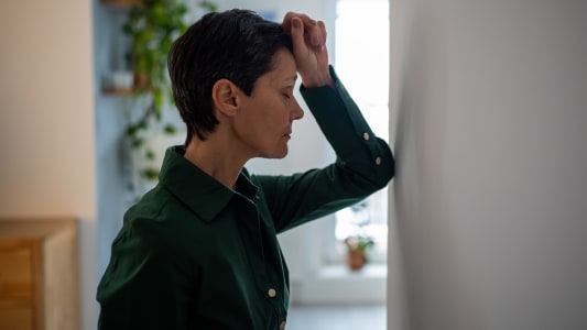 Une femme s'appuyant sur un mur.