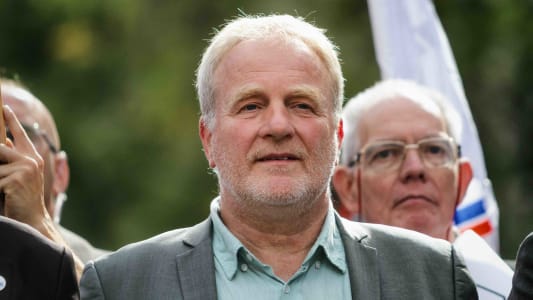 Homme chauve souriant lors d'un rassemblement en extrieur. Franois Hommeril