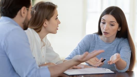 Deux personnes en colre devant une autre personne.