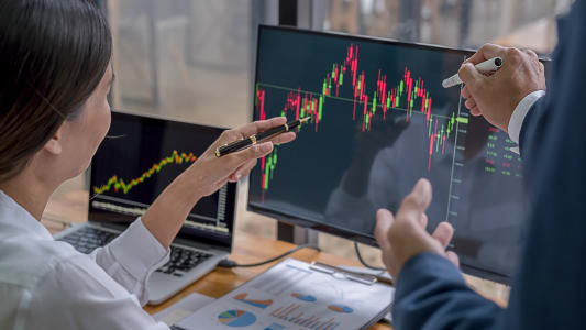 Deux personnes regardant un graphique sur un ordinateur.