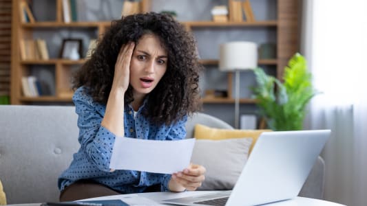 Une femme regardant un document, choquée.