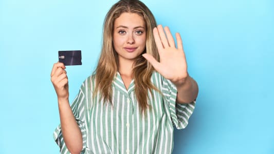 Femme tenant une carte et faisant un geste de refus.