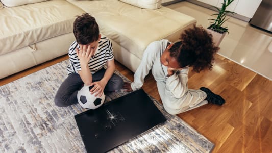 Des enfants devant une tlvision casse, avec un ballon.