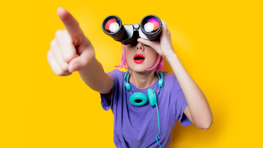 Jeune fille de style dans des vtements violets avec des jumelles sur fond jaune. Vtements de style des annes 1980.