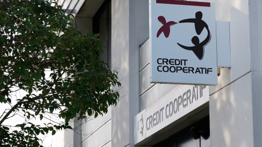 Logo et texte du Cr&eacute;dit Coop&eacute;ratif devant le mur de l'agence bancaire du b&acirc;timent de bureau