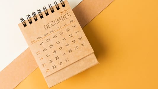Calendrier de bureau vierge pour dcembre 2025 sur fond de ton brun.