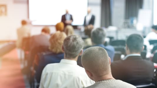 Prsentation professionnelle devant un groupe de personnes assises.