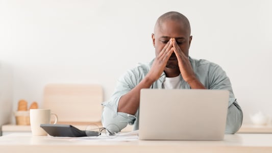 Un homme regardant son ordinateur l'air pr�occup�.