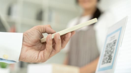 Les clients utilisent des smartphones pour scanner les codes QR afin de payer en magasin avec des paiements num�riques sans esp�ces