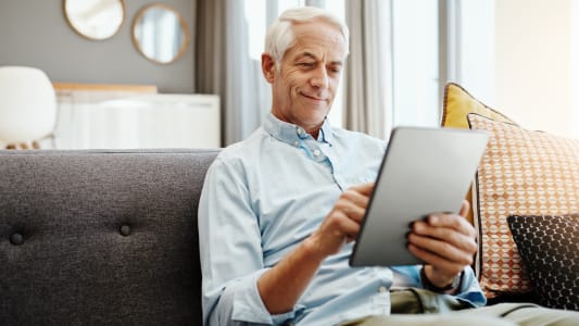 Personne �g�e, tablette et retraite � la maison pour taper des emails, communiquer et lire des nouvelles en ligne. Personne �g�e, technologie et d�tente sur le canap� dans le salon pour le paiement des factures, la vid�o et la lecture d'ebook