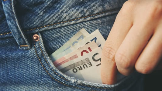 Des billets dans la poche de jeans en gros plan