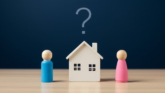 Deux figurines face à une maisonnette avec un point d'interrogation.