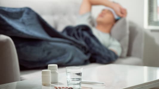 Un homme malade allongé sur son canapé.