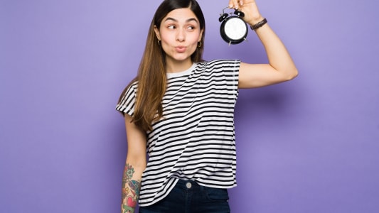 Une femme faisant un compte à rebours avec une horloge