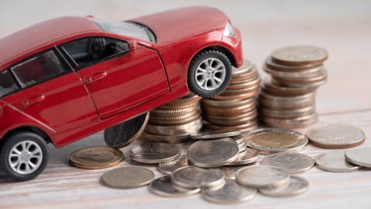 Une voiture miniature sur une pile de pi�ces.