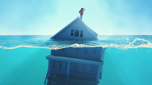 Une maison sous l'eau, avec quelqu'un sur son toit