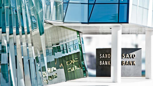 Bâtiment moderne en verre avec le logo Saxo Bank.
