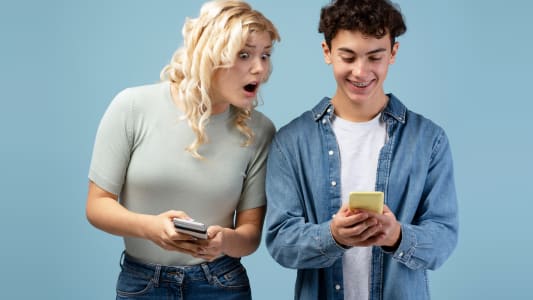 Fille et garçon tenant des téléphones mobiles