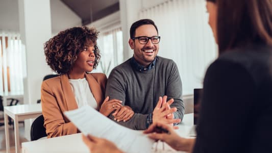 Une femme et un homme face &agrave; une personne tenant un document.