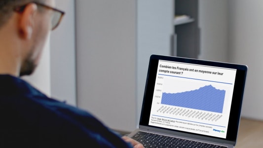 Homme regardant un graphique financier sur un ordinateur portable.