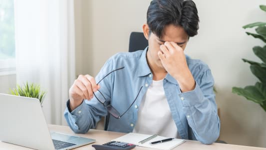 Concept de probl&egrave;me oculaire, jeune homme asiatique fatigu&eacute;, yeux fatigu&eacute;s chez l'homme, nez irrit&eacute; par le frottement, soulagement de la douleur oculaire apr&egrave;s le travail sur un ordinateur portable, fatigue oculaire, main tenant des lunettes, souffrant de migraine, mauvaise vision floue.