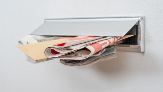 Du courrier dépassant d'une boîte aux lettres.