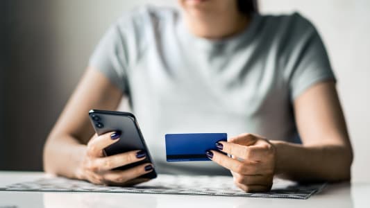 Carte de cr&eacute;dit et t&eacute;l&eacute;phone pour le paiement. Femme faisant du shopping et payant. Arnaque ou fraude. Transaction mobile. Argent transf&eacute;r&eacute; en banque. Achat avec une application smartphone. Fille ou &eacute;tudiante utilisant la technologie.