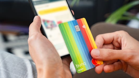 Carte bancaire color&eacute;e utilis&eacute;e pour achat en ligne sur smartphone.