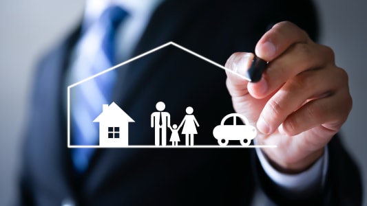 Un homme d'affaires dessinant une protection et une voiture, une famille, la vie et la sant&eacute;.