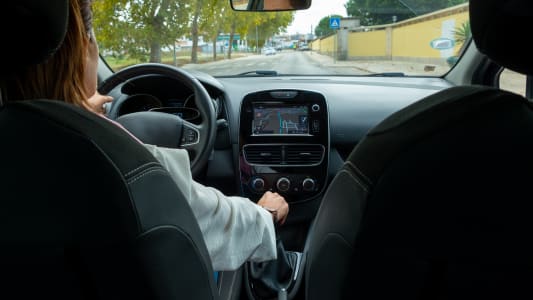 Une femme conduisant dans le village. Vue depuis le si&egrave;ge arri&egrave;re du passager.