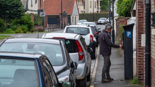 Un homme paie son stationnement.
