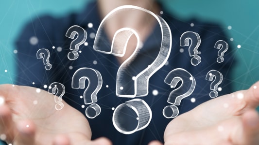 Femme d'affaires touchant et tenant des points d'interrogation dessin&eacute;s &agrave; la main