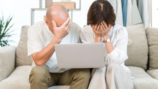 Couple de personnes &acirc;g&eacute;es choqu&eacute; en regardant leur &eacute;cran d'ordinateur