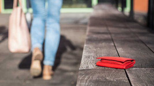 Une femme part d'un banc o&ugrave; elle a oubli&eacute; son portefeuille.