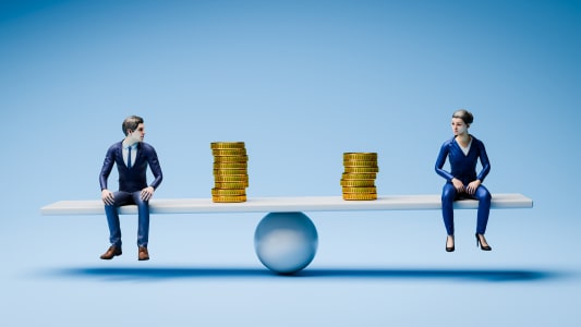 Concept d'&eacute;galit&eacute; salariale : une figurine d'homme et de femme en tenue d'affaires assise sur une balance / bascule avec un nombre diff&eacute;rent de pi&egrave;ces d'or &agrave; c&ocirc;t&eacute; d'eux.