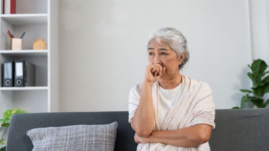 Femme &acirc;g&eacute;e &agrave; la maison assise sur le canap&eacute; se sentant inqui&egrave;te, anxieuse et triste. Soulignant les d&eacute;fis de la sant&eacute; mentale chez les personnes &acirc;g&eacute;es